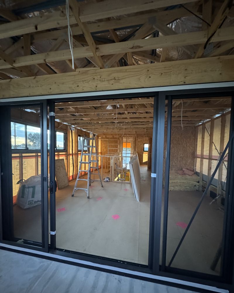 New glazed sliding doors installed, with the timber frame and roof trusses beyond