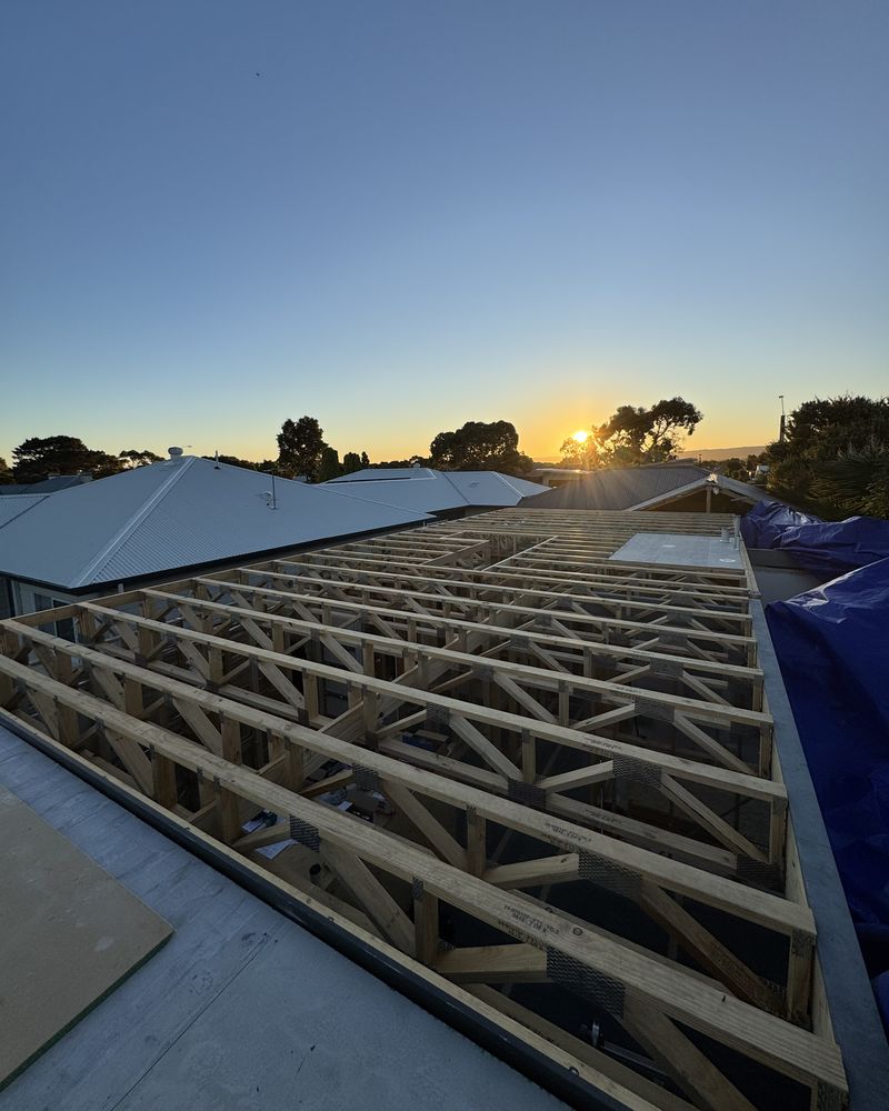 The original roof removed and new floor trusses laid across the house at sunrise